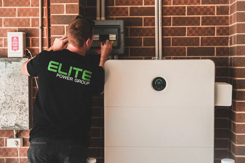 Instalator montuje domowy magazyn energii na ścianie